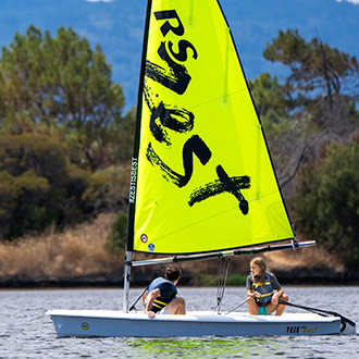 Two kids in the water with their boat. Two kids in the water with their boat.